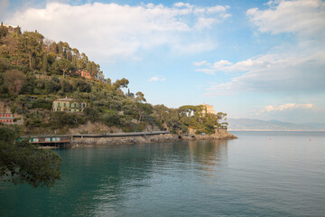Stunning coastal view of a hillside with lush vegetation and calm waters at dusk