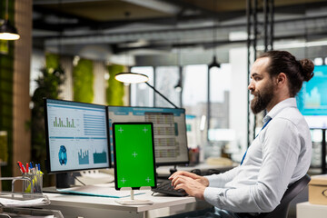 Executive assistant analyzing KPI metrics on pc next to tablet with mockup, handling task completion with infographics and data analytics on the computer. Businessman seeing insights.