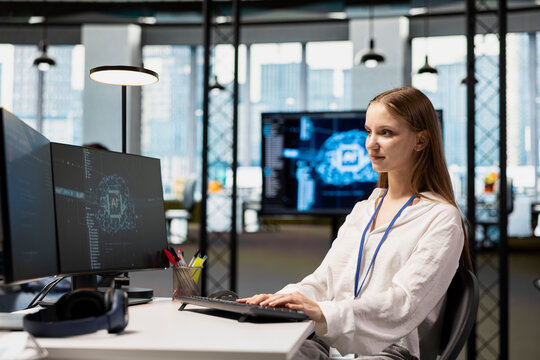 Female technician adjusting deep learning algorithms parameters at work to automate tasks. Young girl in technology company working with AI driven insights for code optimization