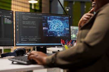 Fototapeta premium Close up of IT specialist in tech startup using artificial intelligence on PC to optimize performance and forecast issues. Technician in office training deep learning models using computer