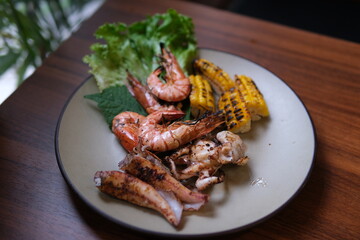 Grilled seafood corn Mixed corn and seafood barbecue. Grilled corn and chicken on the barbecue. Grilled prawns sizzle on the barbecue when the prawn is flipped.