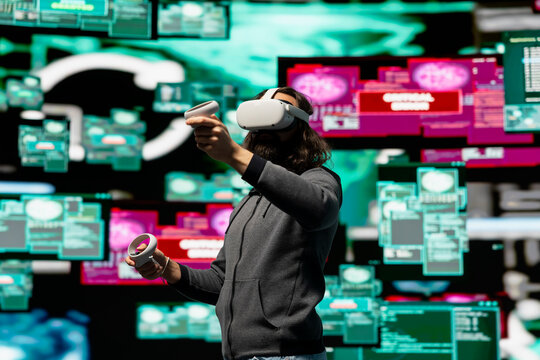Man uses virtual reality headset for system corruption and password cracking, cyber intelligence define this tech driven information theft. Intrusion and threat alerts reveal dangerous hacking. - Powered by Adobe