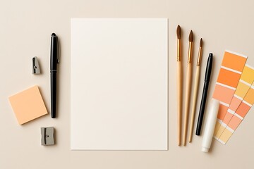 Art supplies laid out on a neutral surface with blank paper