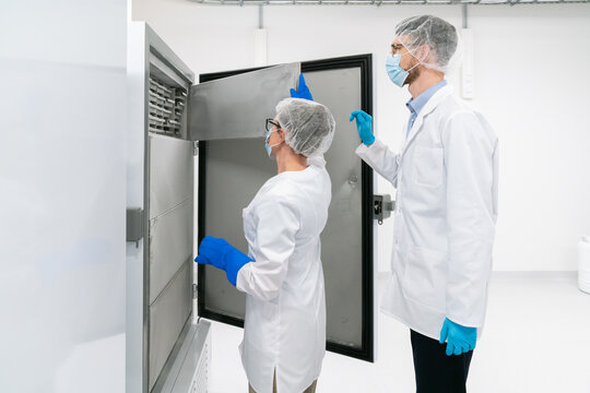 Lab Technicians Handling Equipment in a Clean Room Environment - Powered by Adobe