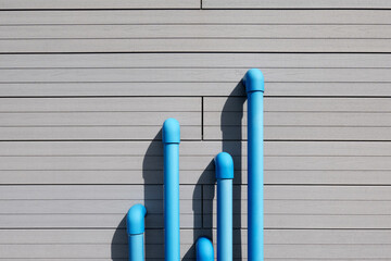 Blue water pipes casting shadows on wall