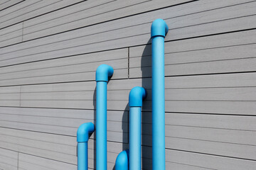 Blue water pipes against modern wall
