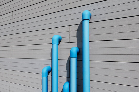 Blue water pipes against modern wall
