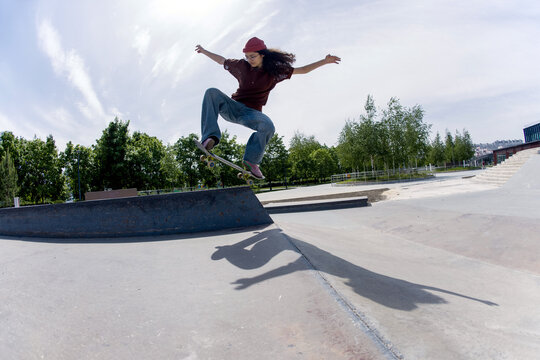 Skater performs an impressive jump over a ledge at a local skatepark