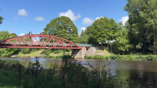 Summer scene with Ronne river and the old historical iron bridge built in 1904 in Angelholm, Sweden