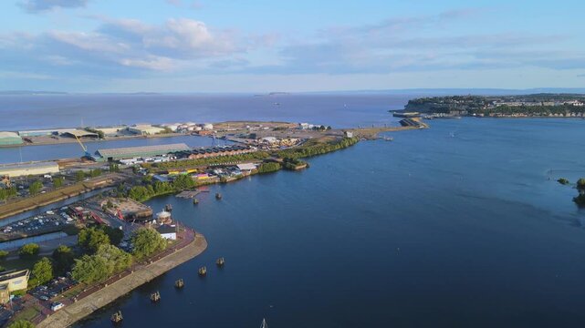 Aerial shot over Cardiff Bay looking towards the barrage with Penarth town on the hill in the backgorund. Shot moves forward while a boat travels towards the camera, Cardiff, UK, 4K, 60fps