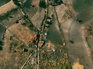 Aerial drone view of an ecotourism center nestled in the mountains, showcasing sustainable lodges surrounded by lush forests and stunning natural landscapes.