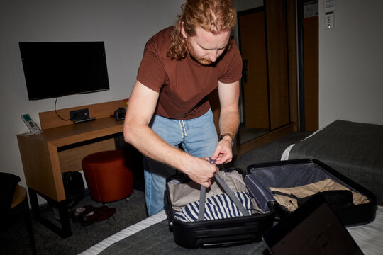Man secures his luggage in a suitcase
