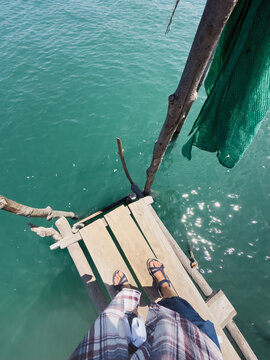 POV adventurous anonymous person on a rustic wooden pier