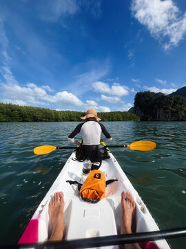 POV kayaker's feet and back of second kayaker in front of him 