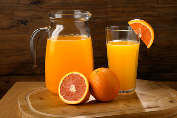 Fresh Orange Juice and Oranges on a Wooden Board