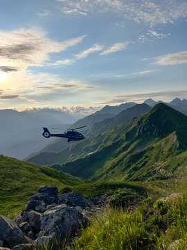 Helicopter flying above alpine ridges