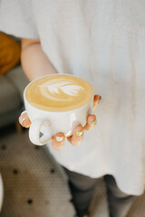 woman holding a cup of coffee barista with latte