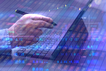 Businessman with stylus in hands using laptop with stock market data, trading charts and analytical overlays. Finance and investment concept with cryptocurrency, online trading and marketing research.