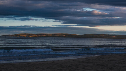 Obraz premium Sunset Over the Ocean and Hills