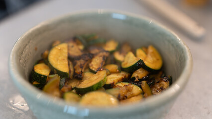 Golden fried zucchini with aromatic herbs served in a rustic bowl. Healthy vegetable dish perfect for food photography, vegan recipes, and clean eating content