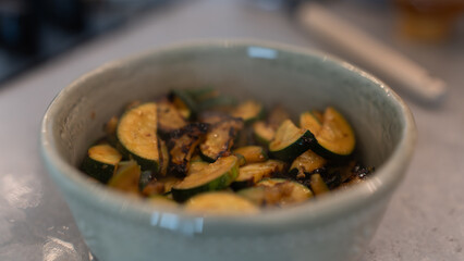 Golden fried zucchini with aromatic herbs served in a rustic bowl. Healthy vegetable dish perfect for food photography, vegan recipes, and clean eating content