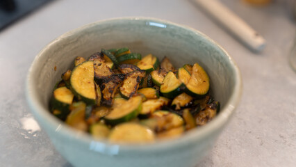 Golden fried zucchini with aromatic herbs served in a rustic bowl. Healthy vegetable dish perfect for food photography, vegan recipes, and clean eating content