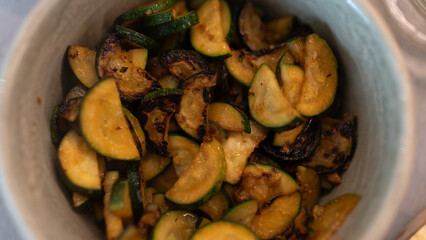 Golden fried zucchini with aromatic herbs served in a rustic bowl. Healthy vegetable dish perfect for food photography, vegan recipes, and clean eating content