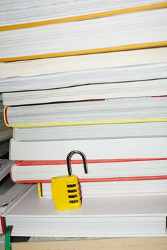 Yellow lock / padlock in bookshelf with hard direct flashlight