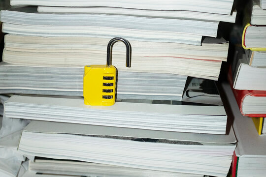 Yellow lock / padlock in bookshelf with hard direct flashlight