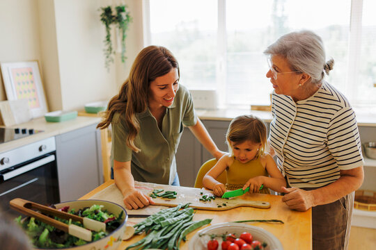 Happy family preparing healthy meal together in modern kitchen