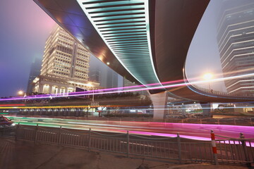 The highway car rainbow light trails of modern city buildings