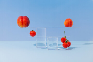 Balancing act with fruits and vegetables on a blue background