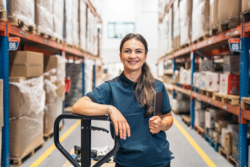 Smiling female logistic worker holding tablet and leaning