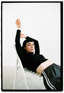 Model poses in minimalist studio setting with stylish athletic w