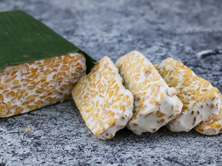 Sliced of Tempeh or tempe on cutting board. Tempeh is a traditional Indonesian food made from fermented soy beans. 