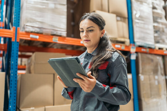 Warehouse worker using digital tablet checking inventorY