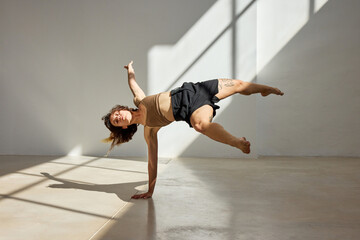 Dancer performs a dynamic move in a bright studio setting