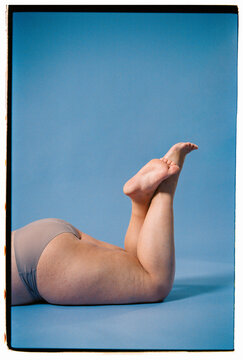 Anonymous plus size woman lying on studio background