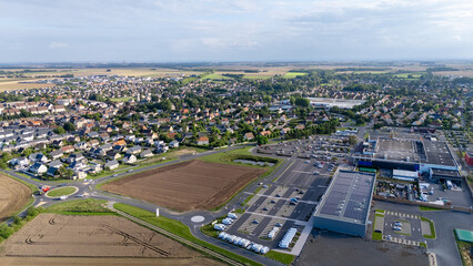 Aerial view of suburban european town with farmland and commercial areas.