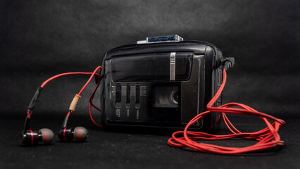 Retro Black Cassette Player with Red Headphones on Dark Surface
