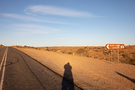 Shadow at sunset with sign at Mundi Mundi Lookout
