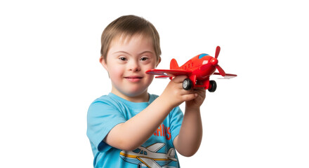 A smiling boy with down syndrome holding a red toy airplane in front of a black background smiling happy