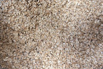 Close-up of raw rolled oats in bulk, showcasing their natural texture and light golden color. Perfect for illustrating healthy eating, natural ingredients, plant-based diets, and whole grain foods. Id