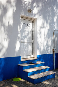 Staff Entrance With Blue Accents and Shadow Patterns During Daytime