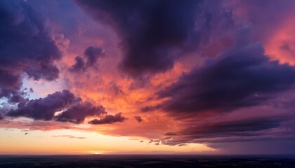 Obraz premium fiery orange pink sky with stormy clouds at dramatic sunrise or sunset