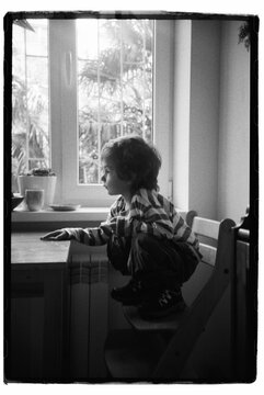 Todler Is Sitting At Home In The Kitchen