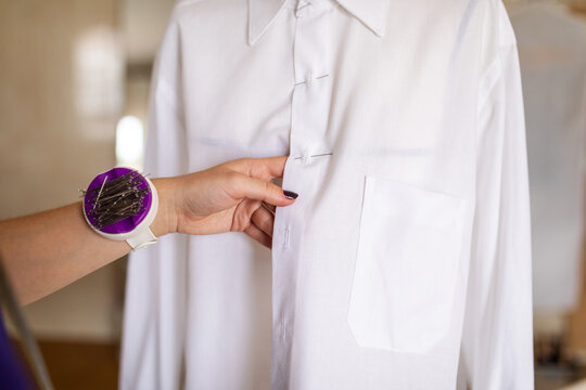 Fashion designer taking measurements in her sewing workshop