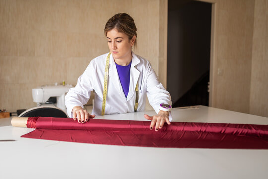 Fashion designer preparing red fabric