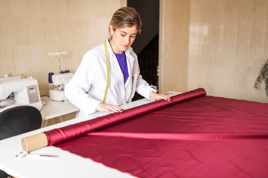 Fashion designer preparing red fabric