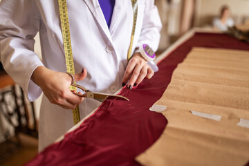 Fashion designer cutting garment patterns